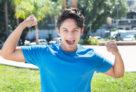 Cheering caucasian guy in a blue shirtの写真素材