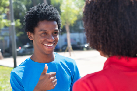 Laughing african american man showing thumb to womanの写真素材