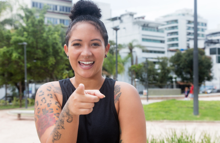 Laughing hipster girl with tattoos and piercing outdoor in the city in the summerの写真素材