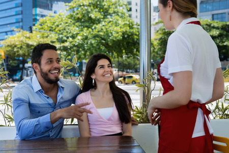 Love couple place an order at a caucasian waitressの写真素材