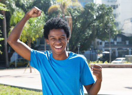 Cheering young african american man outdoor in the city in the summerの写真素材
