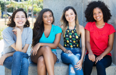 Group of latin and caucasian girl with young african american and hispanic woman outdoor in the summer in the cityの写真素材