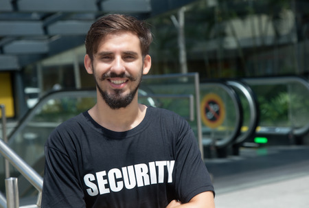 Laughing security guard safes the entrance outdoorの写真素材