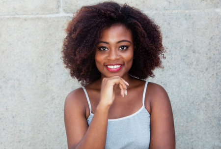 Laughing african american woman with typical afro hair outdoor in the summerの写真素材