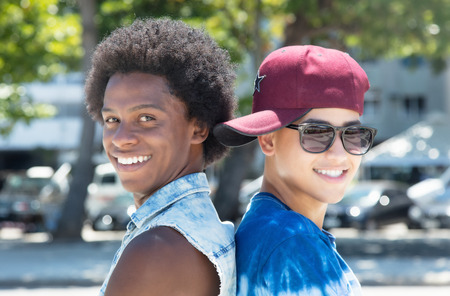 Two cool guys looking at camera outdoor in the summer in cityの写真素材
