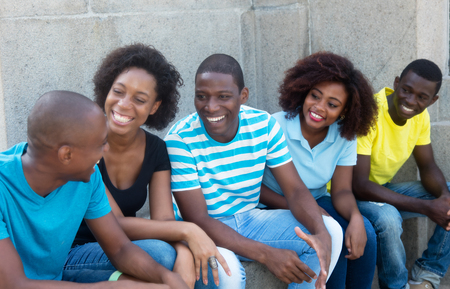 Talking group of african american men and women outdoors in the summerの写真素材