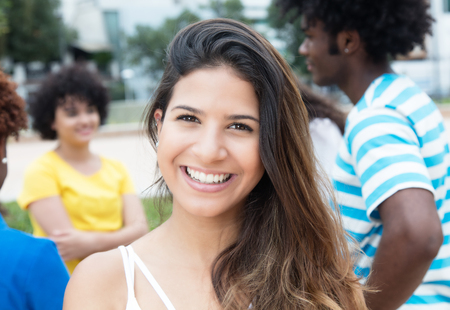 Joyful laughing caucasian woman with large group of international students outdoor at campus of...