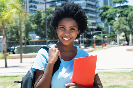 Laughing african american female student looking at camera on campus of universityの写真素材