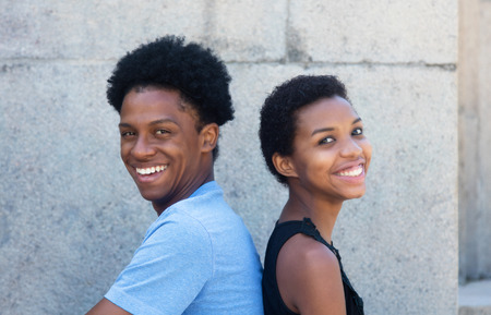 Joyful laughing african american couple looking at camera outdoor in the summerの写真素材