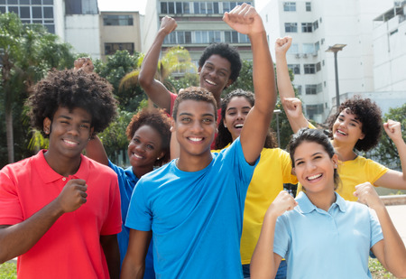 Successful cheering group of international team of young adults outdoors in the summer in the cityの写真素材