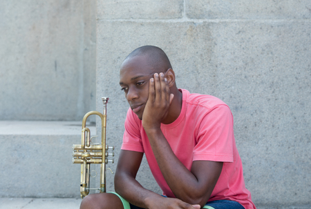 Unsuccessful african american artist with trumpet outdoor in the summerのeditorial素材