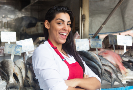 Happy woman selling fresh fish on a typical latin american fish marketのeditorial素材