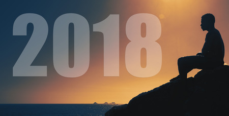 2018 Man sitting on hill at sunset