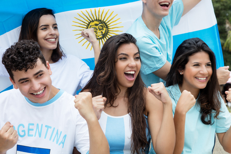 Group of cheering soccer fans from Argentina with argentinian flagの写真素材