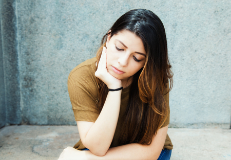 Sad latin american young adult womanの写真素材