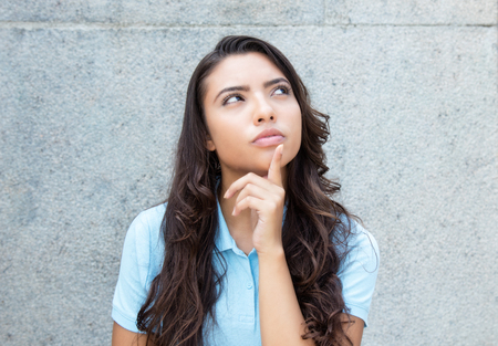 Thinking latin american woman with long hair outdoor in the summerの写真素材