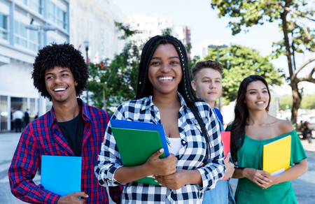 Laughing african female student with group of international students outdoor in the cityの写真素材