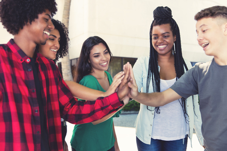 Laughing latin and african american men and women building a team in the cityの写真素材