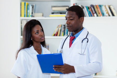 African american male doctor talking with nurse about patientの写真素材