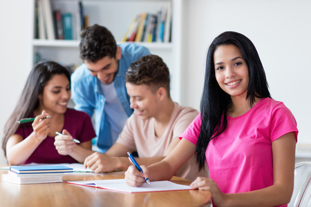 Mexican female student learning with group of studentsの写真素材
