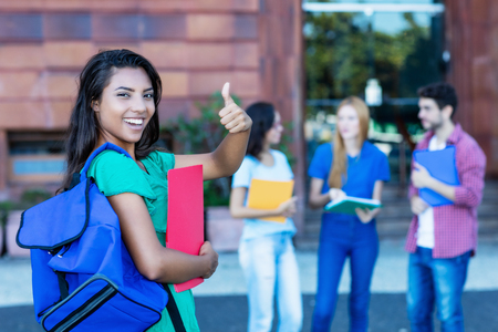 Successful latin american female student with group of studentsの写真素材