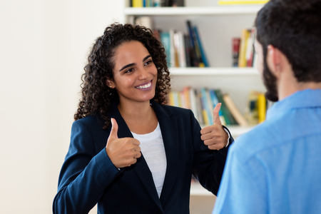 Laughing mexican businesswoman talking with businessmanの写真素材