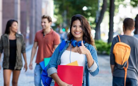 Pretty caucasian young adult woman walking in city with group of studentsの写真素材