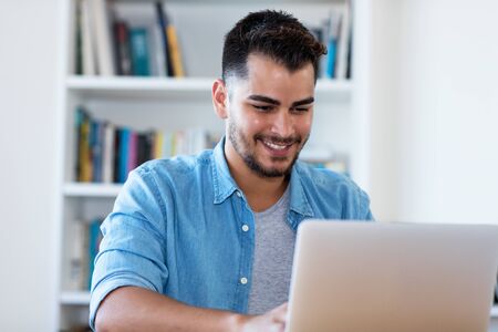 Handsome mexican hipster man at work with laptopの写真素材