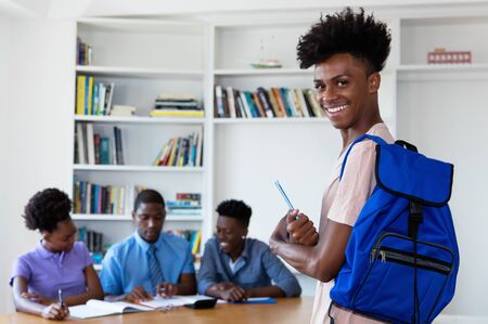 Handsome african student at classroom with group of young adults
