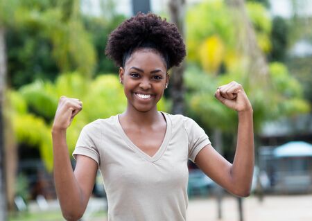 Cheering caribbean woman with afro hairの写真素材