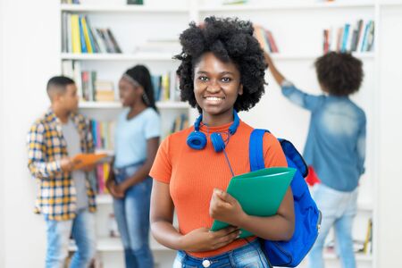 Beautiful african american female student with group of studentsの写真素材