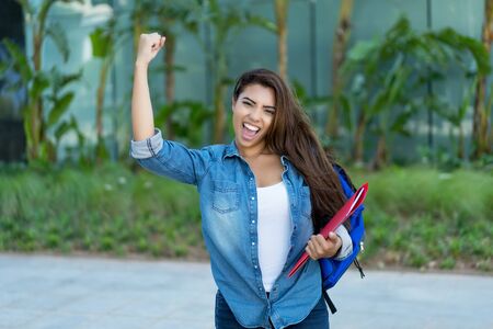 Cheering latin american female student in cityの写真素材