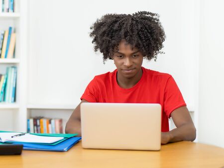 Working african american male student in quarantine at computerの写真素材
