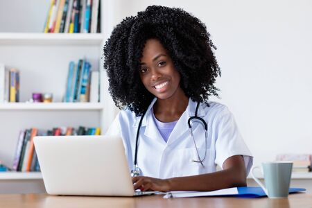 Laughing african american nurse or medical student at computerの写真素材