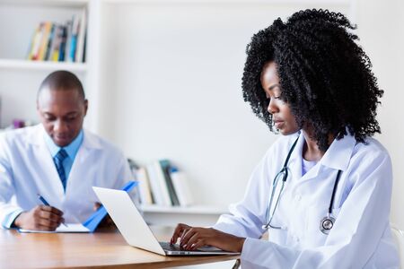 African american medical student at computer with male doctorの写真素材