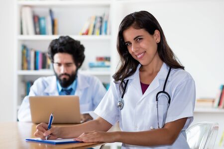 Laughing latin medical female student with doctorの写真素材