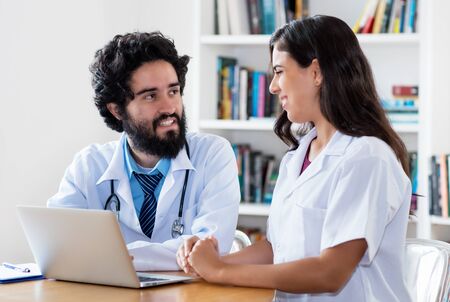 Arabic male doctor talking with medical student about patientの写真素材