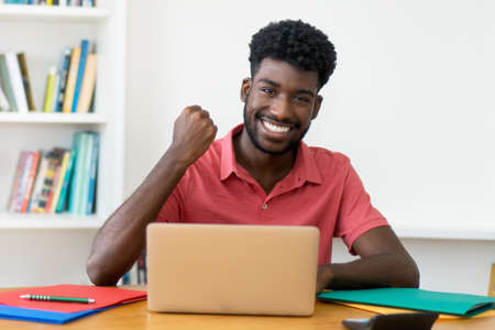 Successful afro american male student learning at computerの写真素材