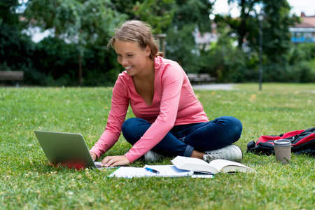 Pretty german female student at computer learning and preparing for degreeの写真素材