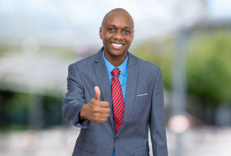 African american businessman showing thumb up outdoors in the cityの写真素材