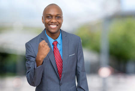Cheering african american businessman outdoors in the cityの写真素材