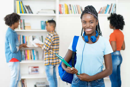 Laughing african american female student with dreadlocks and group of young adultsの写真素材