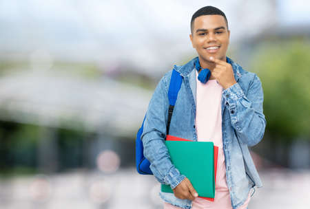 Smiling brazilian male student with braces outdoor in city in summerの写真素材