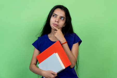 Thinking Indian female student with books and paperworkの写真素材