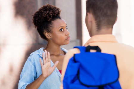 Young african american woman gesturing stop and rejecting man