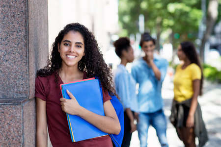 Laughing brazilian female student with group of young adultsの写真素材