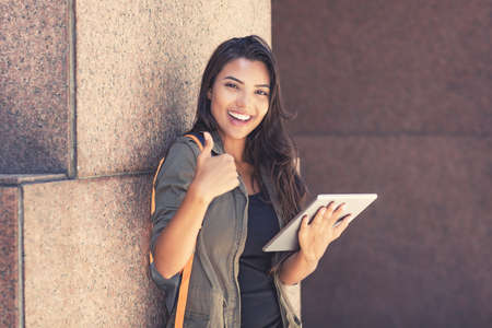 Latin american female student with digital tablet computer showing thumb upの写真素材