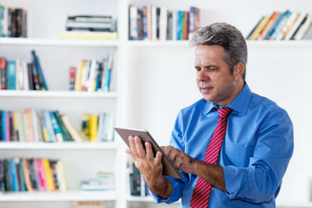Businessman reading business news online with tablet computerの写真素材