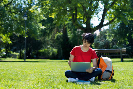 Korean male student learning at computer at campus of universityの写真素材