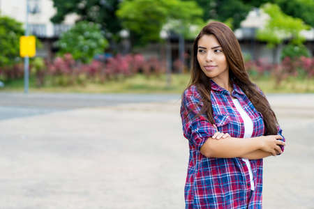 Confident latin american young adult woman with long dark hair and copy spaceの写真素材